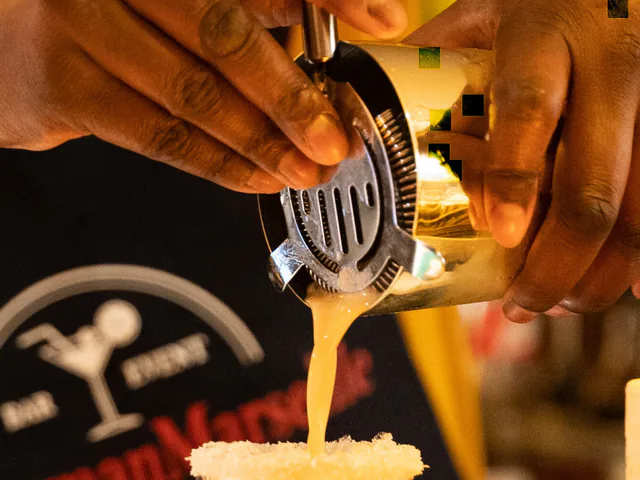 Bartender en tablier AlloBarmanMarseille versant un cocktail