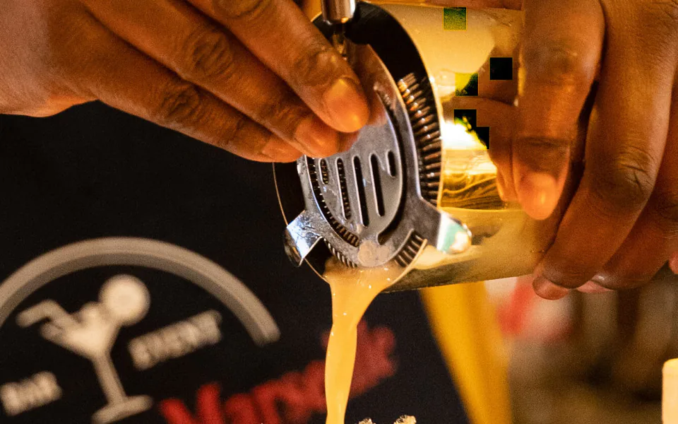 Bartender versant un cocktail au shaker, tablier AlloBarmanMarseille