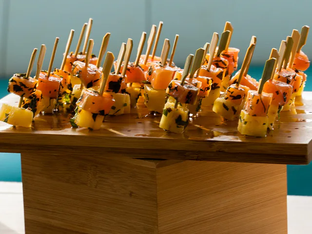 Bouchées de cocktail sur un plateau en bois, avec la mer en arrière-plan