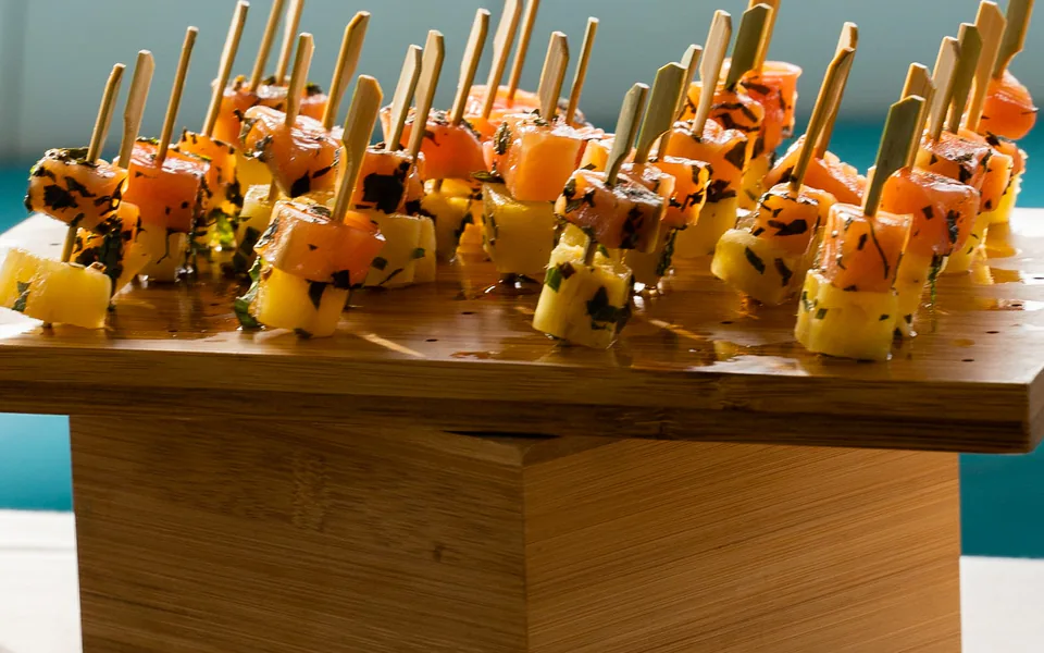 Plateau de bouchées de cocktail dînatoire posé sur une table, vue sur la mer