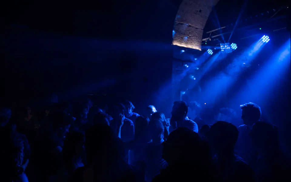 Foule en soirée sous des lumières bleues devant une scène