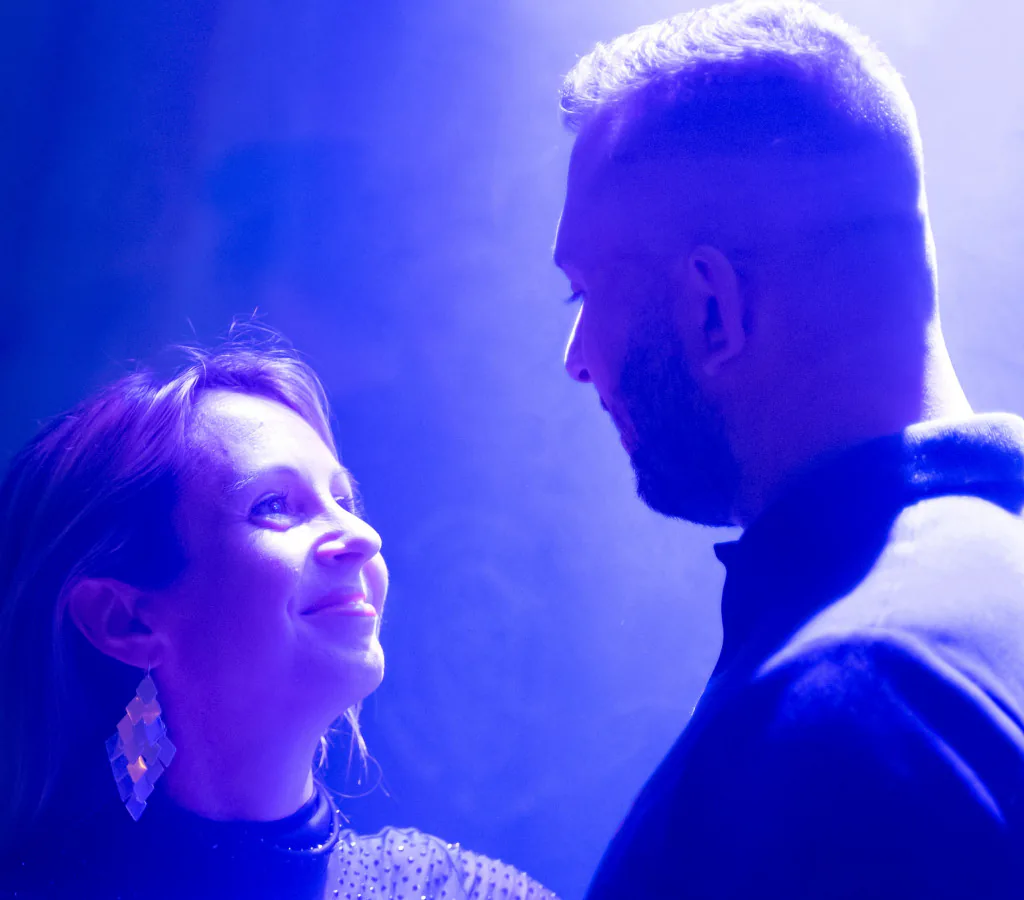 Couple qui danse sous une lumière bleue pendant une soirée