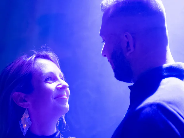 Couple qui danse sous une lumière bleue pendant une soirée