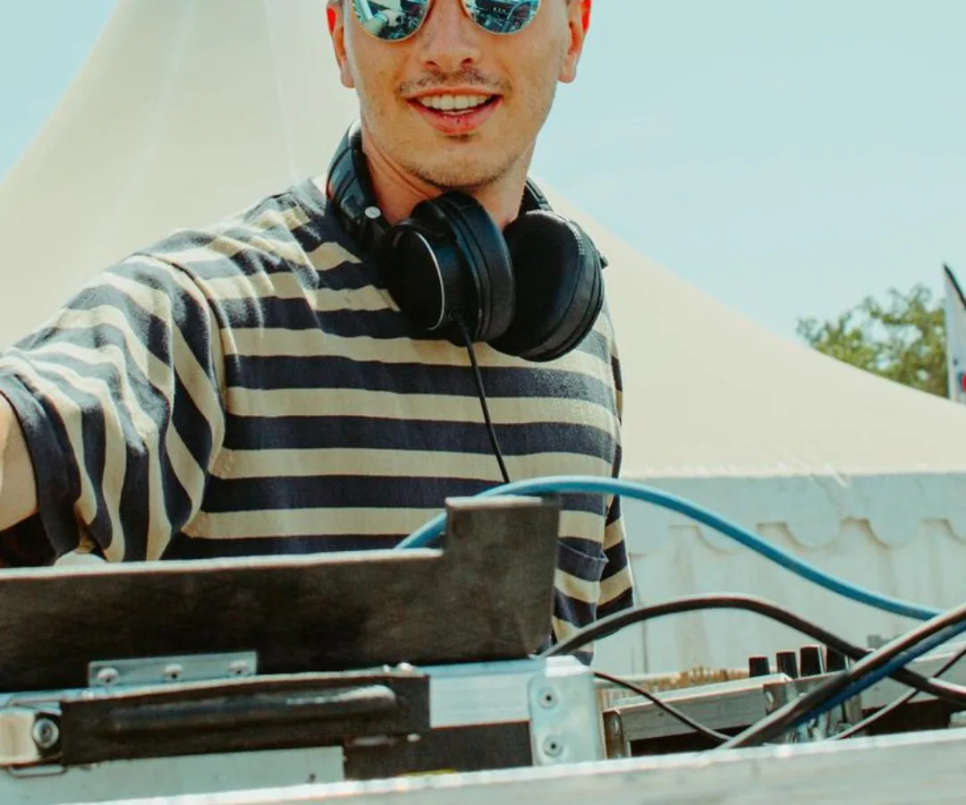 Jeune DJ aux platines sous un chapiteau