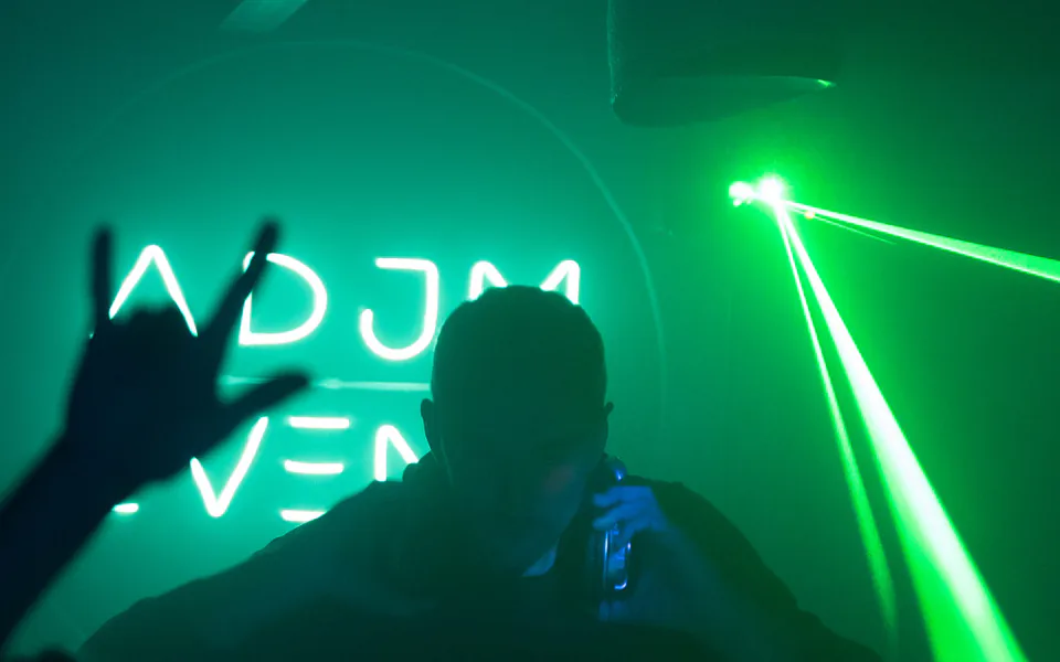 DJ en soirée sous un faisceau laser vert