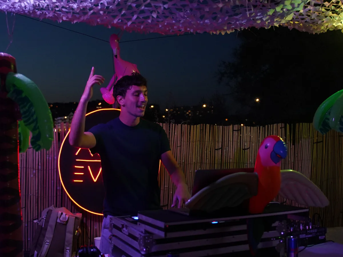 DJ ADJM en soirée extérieure devant le néon ADJM Event