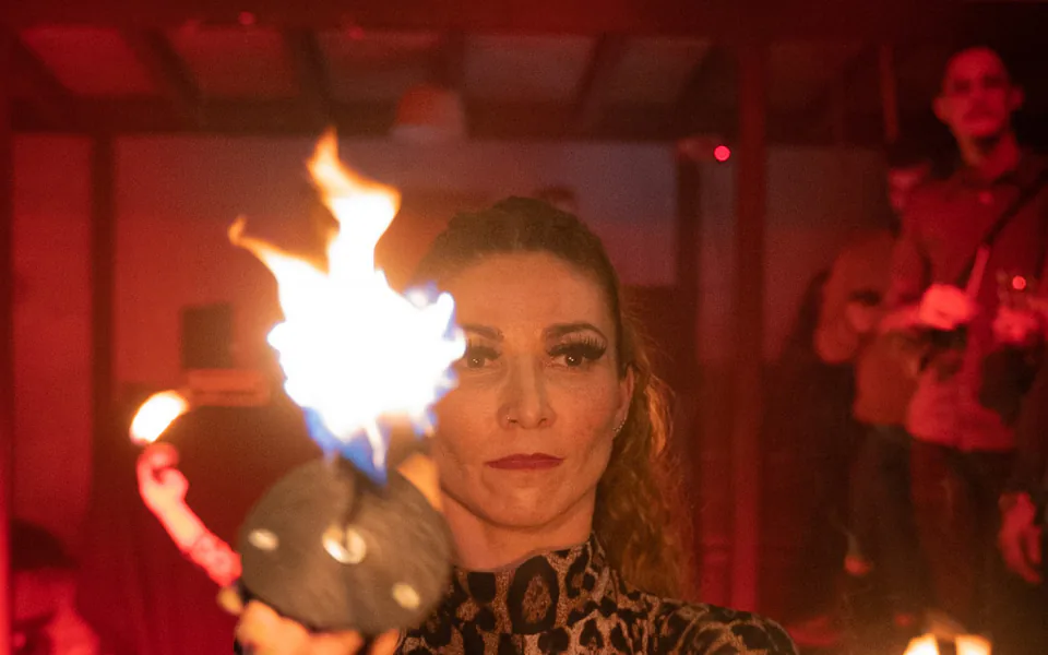 Performeuse jonglant avec des torches enflammées de nuit