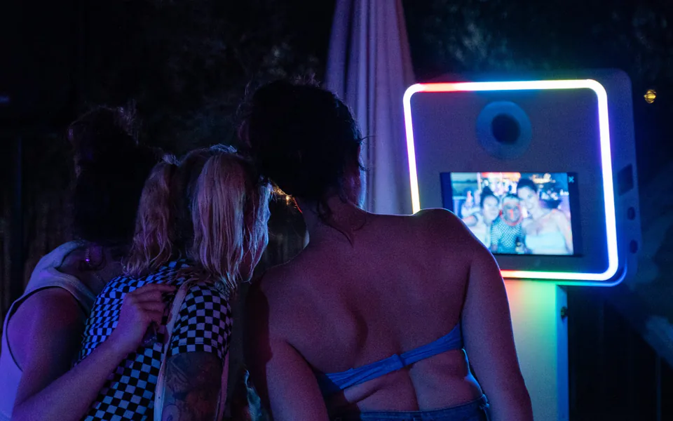Invités devant une borne photobooth pendant une soirée