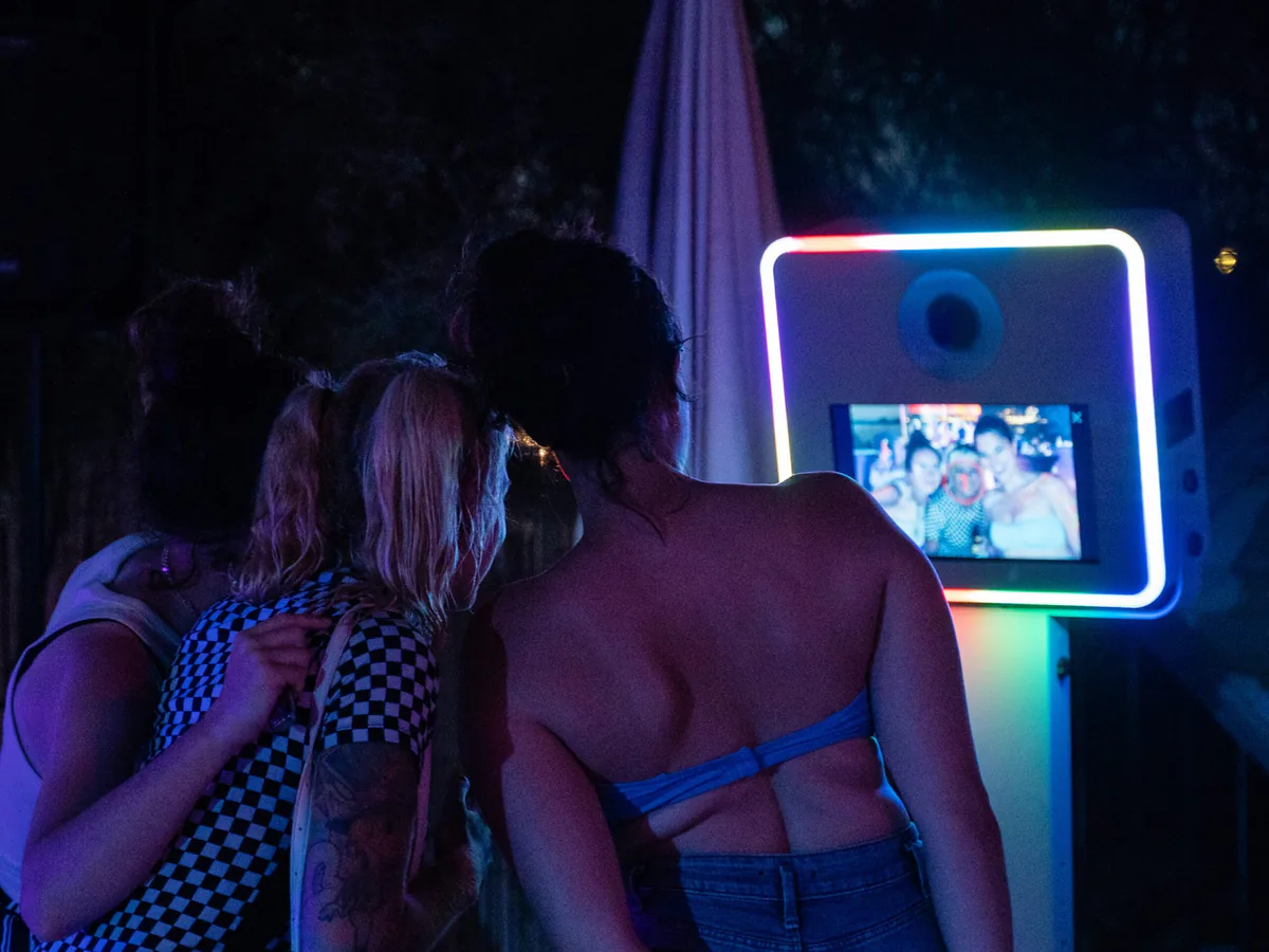 Invités qui posent devant une borne photobooth