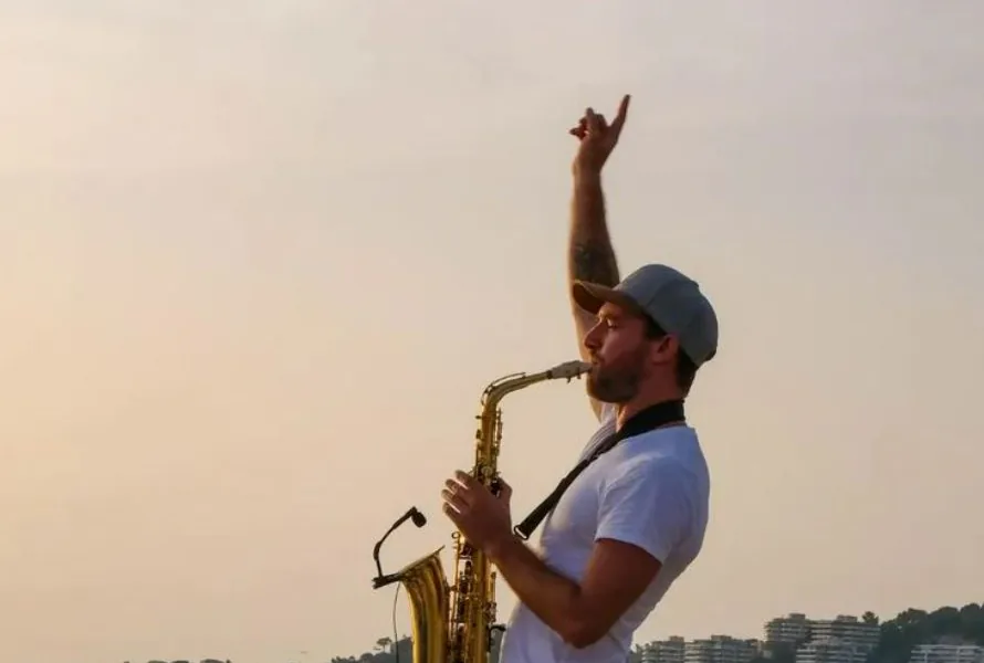 Saxophoniste jouant au coucher du soleil face à la mer à Marseille