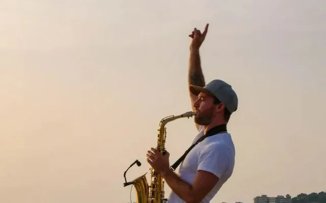 Saxophoniste jouant au coucher du soleil face à la mer à Marseille