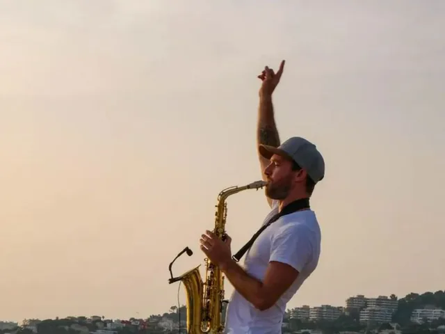 Saxophoniste jouant face à la mer au coucher du soleil à Marseille
