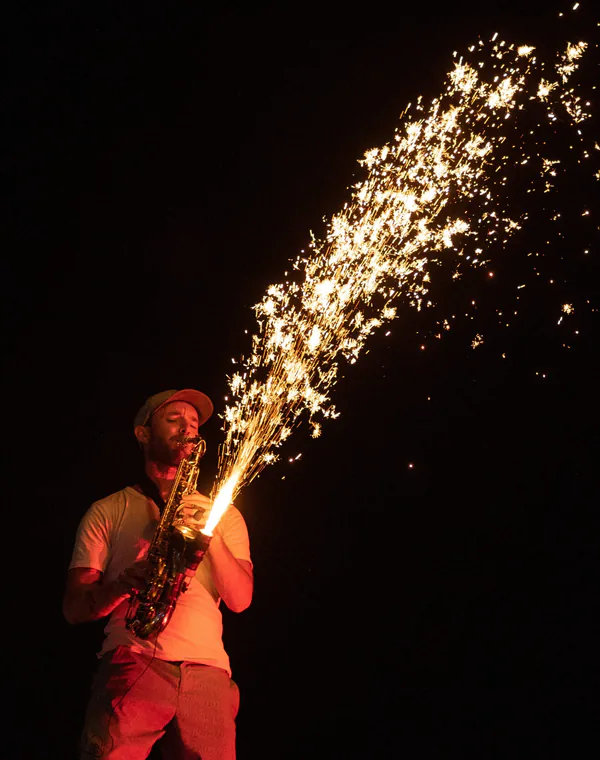 Saxophoniste devant une fontaine d’étincelles