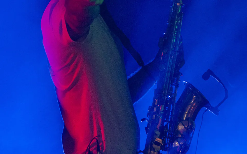 Saxophoniste jouant en soirée sous une lumière bleue