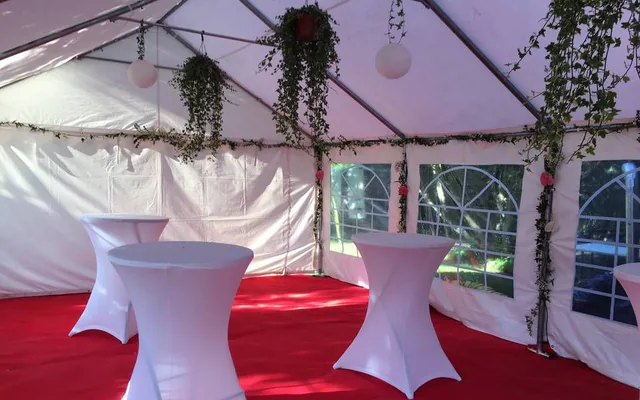 Tente de réception blanche avec mange-debout et moquette rouge