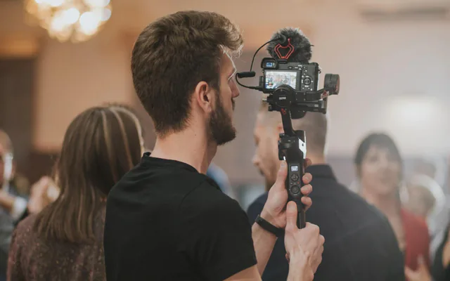 Vidéaste qui filme un événement avec un stabilisateur
