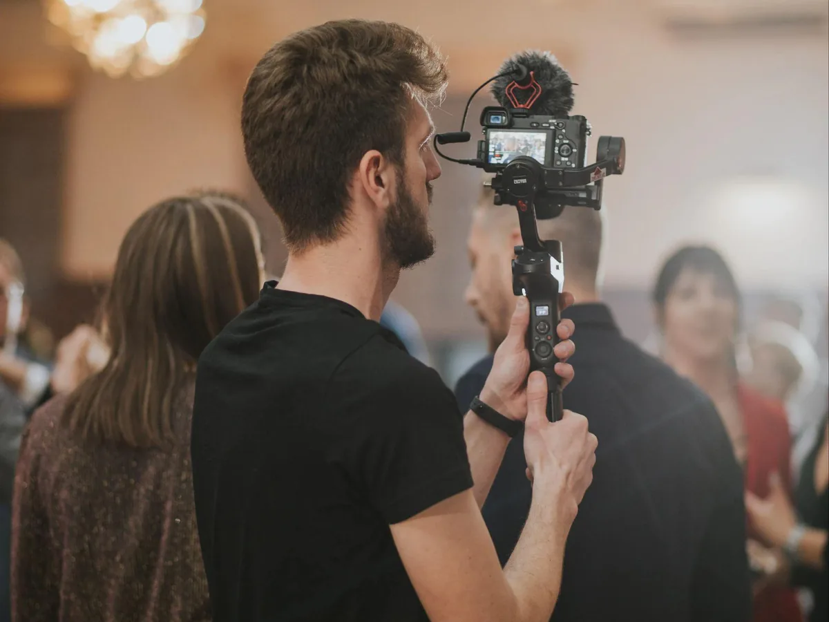 Vidéaste filmant avec un stabilisateur pendant un événement